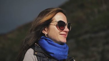 Kadın yüz portre kadar kapatın. Doğruca kameraya, arayan kadın gözlük, gülümseyen. Güneş ışınları. Yakın çekim