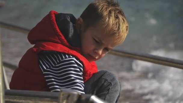 这个孩子8岁了。用棍子在沙滩上玩耍. — 图库视频影像
