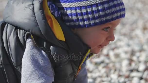 Een kind op het strand kruipt op kiezels. — Stockvideo