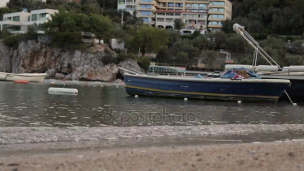 Small traditional fishing boat tied at the beach under clear blue sky — Stock Video