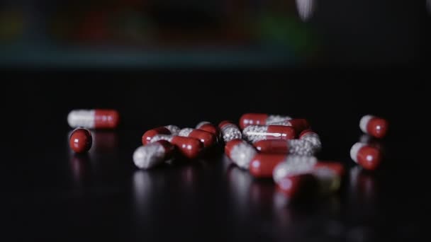 Medical pills scattered on the black table — Stock Video