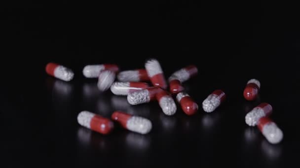 Medical pills scattered on the black table — Stock Video