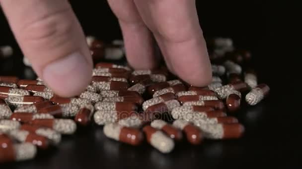 Pills scattered on the table fingers take a pill — Stock Video