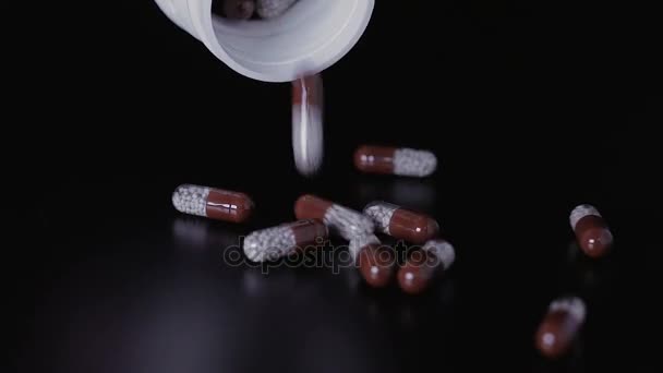 Pilules médicales dispersées sur la table noire — Video