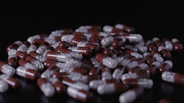 Pilules médicales dispersées sur la table noire — Video