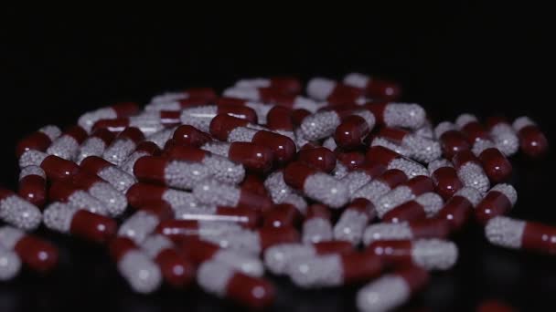 Medical pills scattered on the black table — Stock Video