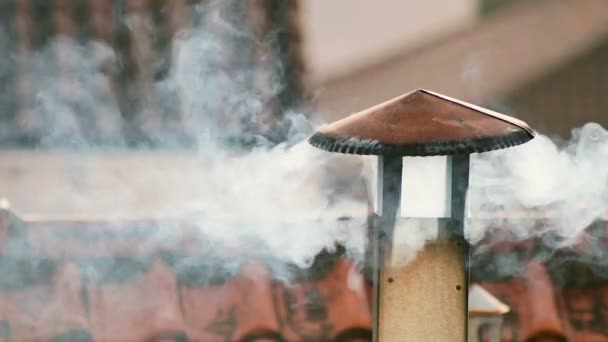 Il fumo viene dal camino di casa. Il tubo sul tetto. Camino. Casa di campagna. La casa con un camino. Fumo sullo sfondo dei tetti — Video Stock