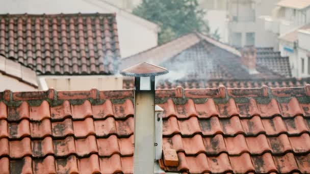 Er komt rook uit de schoorsteen van het huis. De pijp op het dak. Schoorsteen. Landhuis. Het huis met een open haard. Roken op de achtergrond van daken — Stockvideo