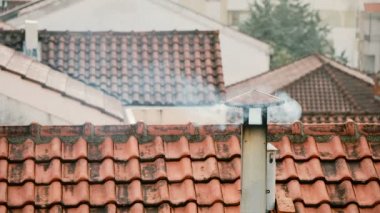 Evin bacasından duman giriyor. Boru çatıda. Baca. Kır evi. Evin baca ile. Çatılar arka plan üzerinde duman