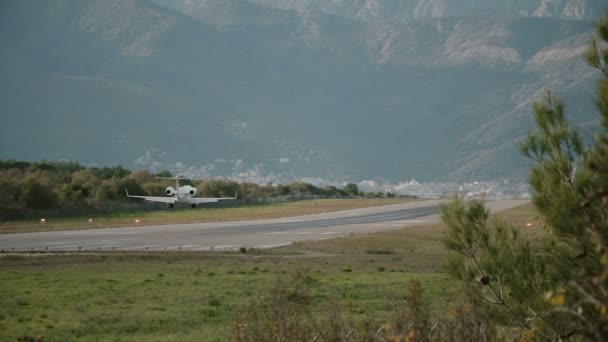 Malé letadlo sedí na přistávací dráha na pozadí hor — Stock video