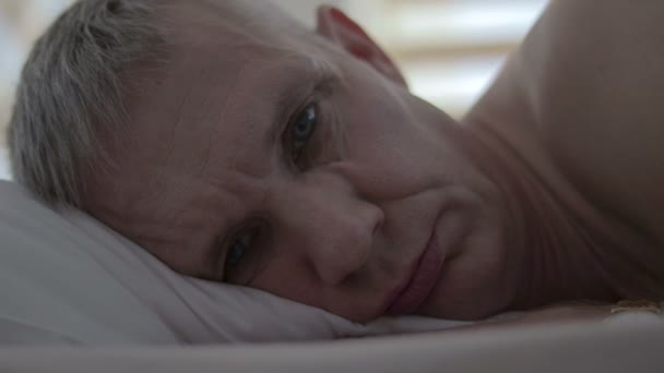 Het gezicht van een boos man die in bed na een mislukte seks ligt — Stockvideo