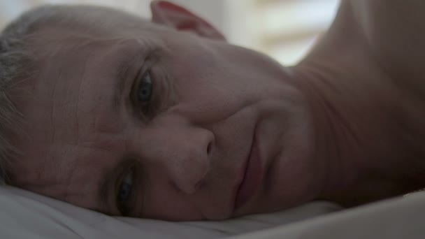 O rosto de um homem chateado que se deita na cama depois de um sexo mal sucedido — Vídeo de Stock