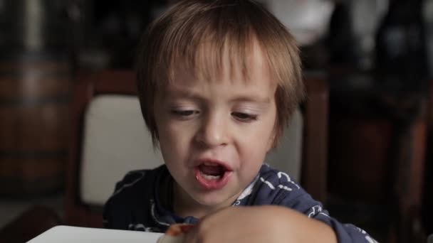 Fechar de menino bonito comendo pizza. Cores neutras para correção de colar . — Vídeo de Stock