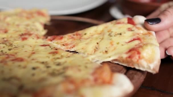 En kvinnlig hand tar en bit pizza med smält ost som sträcker sig — Stockvideo