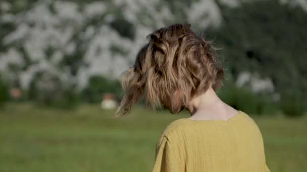 Una chica camina en un campo al atardecer Montenegro 20.06.2018 — Vídeos de Stock