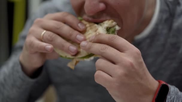 Hombre come sándwich con pollo con mayonesa — Vídeos de Stock