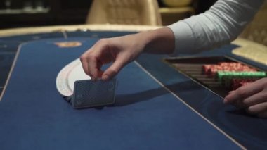 Dağıtıcı kumarhanedeki kumar masasına güzel bir şekilde kartları serer.