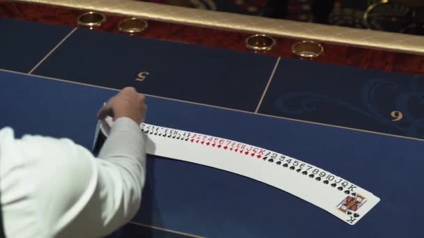 Dealer legt prachtig kaarten op de kaarttafel in het casino — Stockvideo