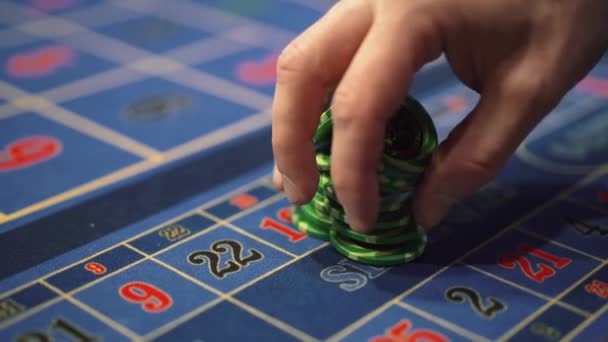 Дилер работает в казино, двигая фишки руками за игровым столом. — стоковое видео