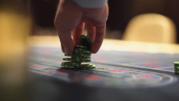 Дилер работает в казино, двигая фишки руками за игровым столом. — стоковое видео