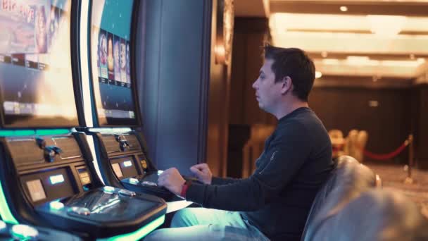 Человек проигрывает в казино в игровых автоматах — стоковое видео