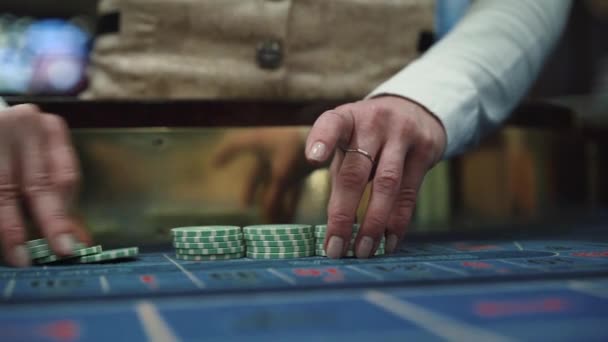 Un mazziere in un casinò detiene giocare fiches con due mani — Video Stock