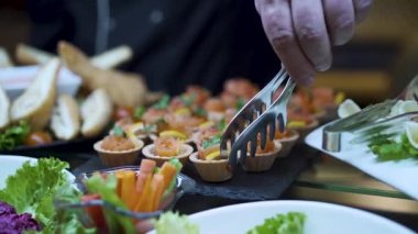 Aşçı abur cuburlarla dolu bir masa hazırlar ve bir sepet kırmızı balık alır. 