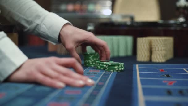 A dealer in a casino holds playing chips with two hands — Stock Video