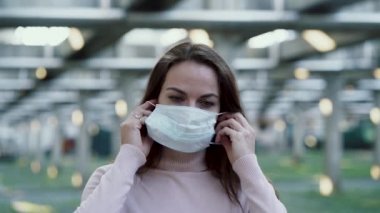 Kız yüzüne koruyucu bir maske takıyor.