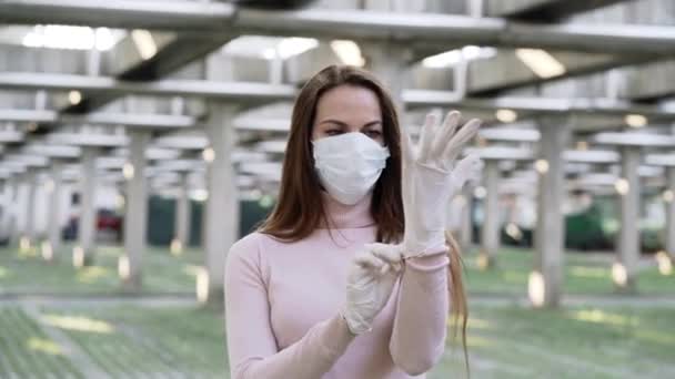 Женщина в защитной маске носит защитные резиновые перчатки — стоковое видео
