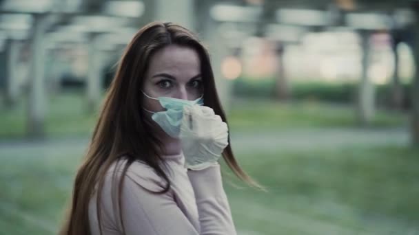 Девушка в защитной маске и резиновых перчатках изображает ужас и страх — стоковое видео