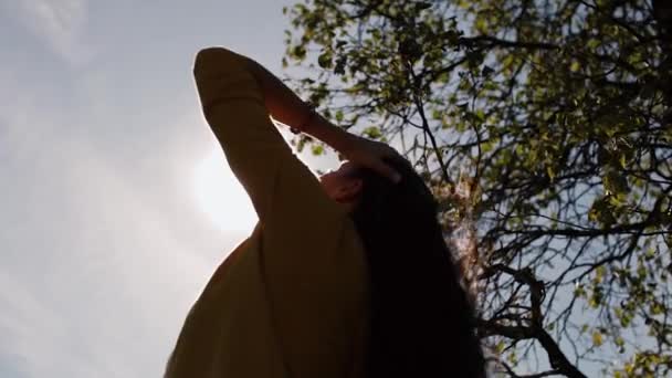Красива дівчина грає з волоссям на сонці — стокове відео