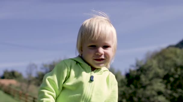 Маленький хлопчик зі світлим волоссям посміхається — стокове відео