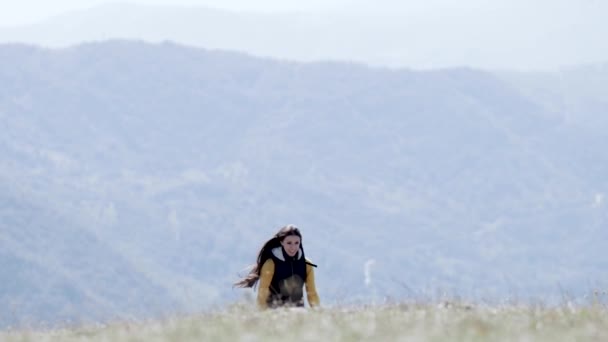Chica corre por la montaña hacia la cámara — Vídeos de Stock