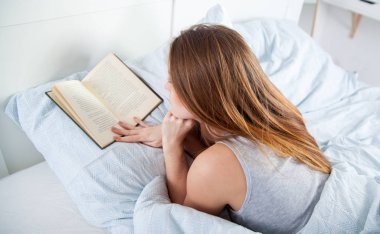 Kız evde yatakta kitap okumak