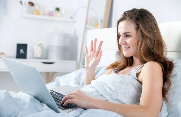 Menina com laptop na cama relaxante em casa — Fotografia de Stock