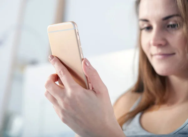 Jeune fille vérifiant son téléphone intelligent, gros plan — Photo