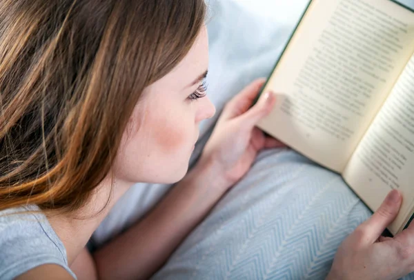 Mädchen liest Buch zu Hause im Bett — Stockfoto