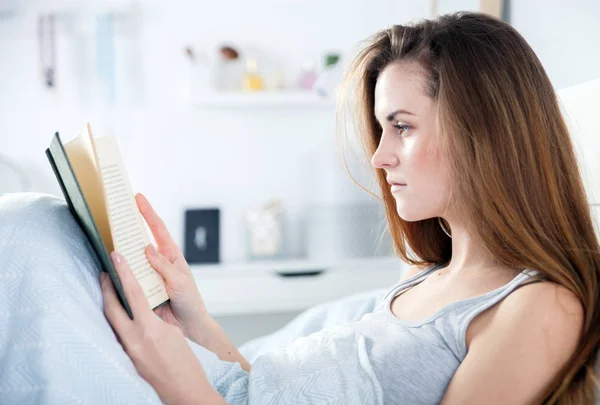 Mädchen liest Buch zu Hause im Bett — Stockfoto