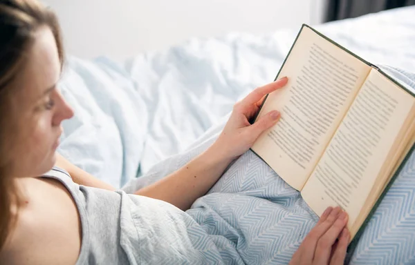 Mädchen liest Buch zu Hause im Bett — Stockfoto