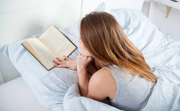 Lány olvasókönyv az ágyban otthon — Stock Fotó