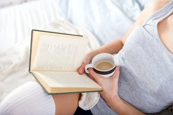 Dívka čtení knihy a pití kávy v posteli doma — Stock fotografie