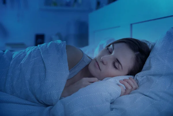 Chica durmiendo tranquilamente en la cama por la noche — Foto de Stock