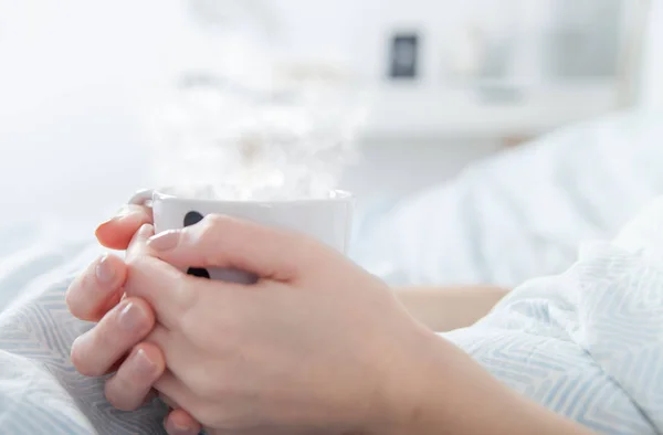 Женщина пьет утренний кофе в постели, закрывается — стоковое фото