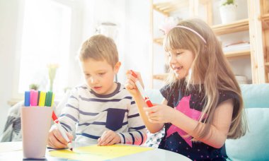 Kız ve erkek kardeşim ile renkli kalemler evde çizim