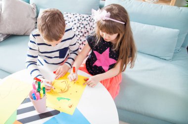 Kız ve erkek kardeşim ile renkli kalemler evde çizim