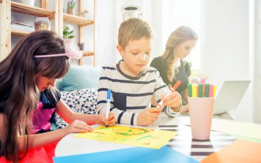 Kardeşler ile renkli kalemler ise anne wor birlikte çizim