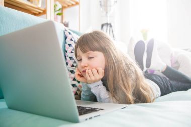Dizüstü evde film izlerken uykulu küçük kız