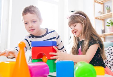 Mutlu bir aile evde, renkli bloklarla oynama kardeşler