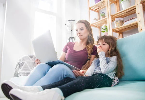 Мать использует ноутбук во время рождения дочери, семья дома — стоковое фото